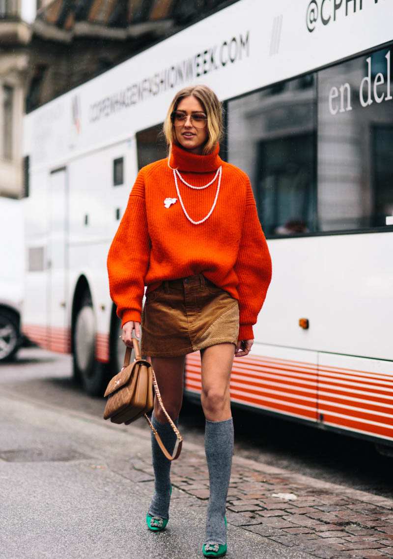 Mini sukňa s oversized svetrom na jesennom outfite na vysokých podpätkoch s ponožkami