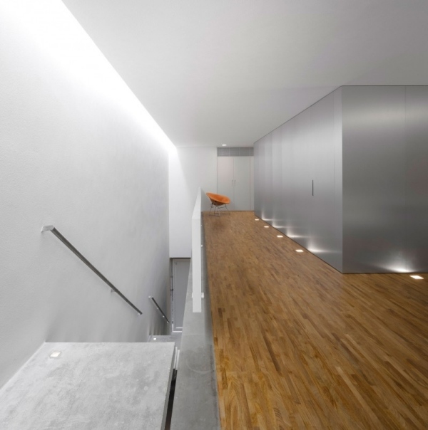 Interiér betónového domu s drevenou podlahou. Biele steny