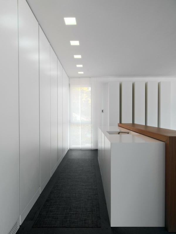 Stropy v predsieni rozžiaria biele steny Stropy na chodbe svietia na tmavé podlahy