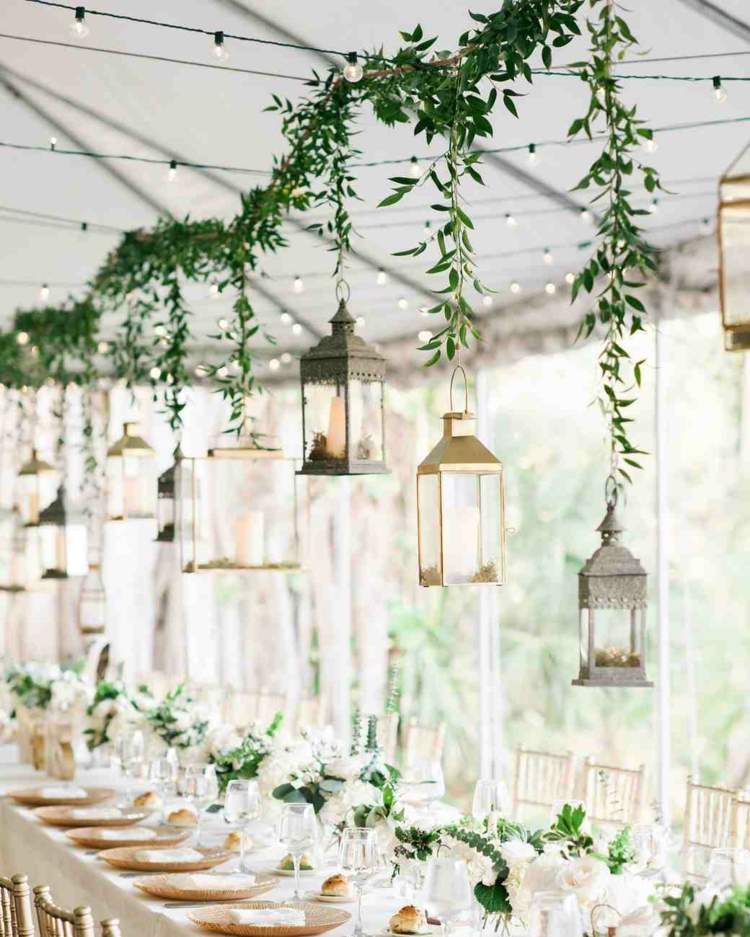 zelený veniec bez kvetov s lampášmi nad dlhým stolom