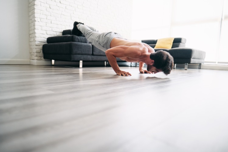 nohy na pohovke robia kliky, cvičenie hrudníka pre mužov doma
