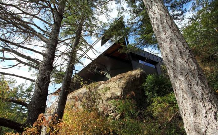 Pohľad zdola - dom sedí na skale moderná architektúra-dom-skaly-more-pobrežie-postavený