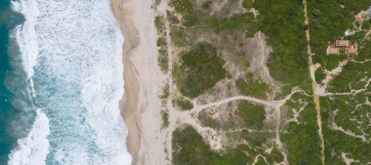 Pobrežie oceánu so surfovou plážou a odľahlými modernými tehlovými domami