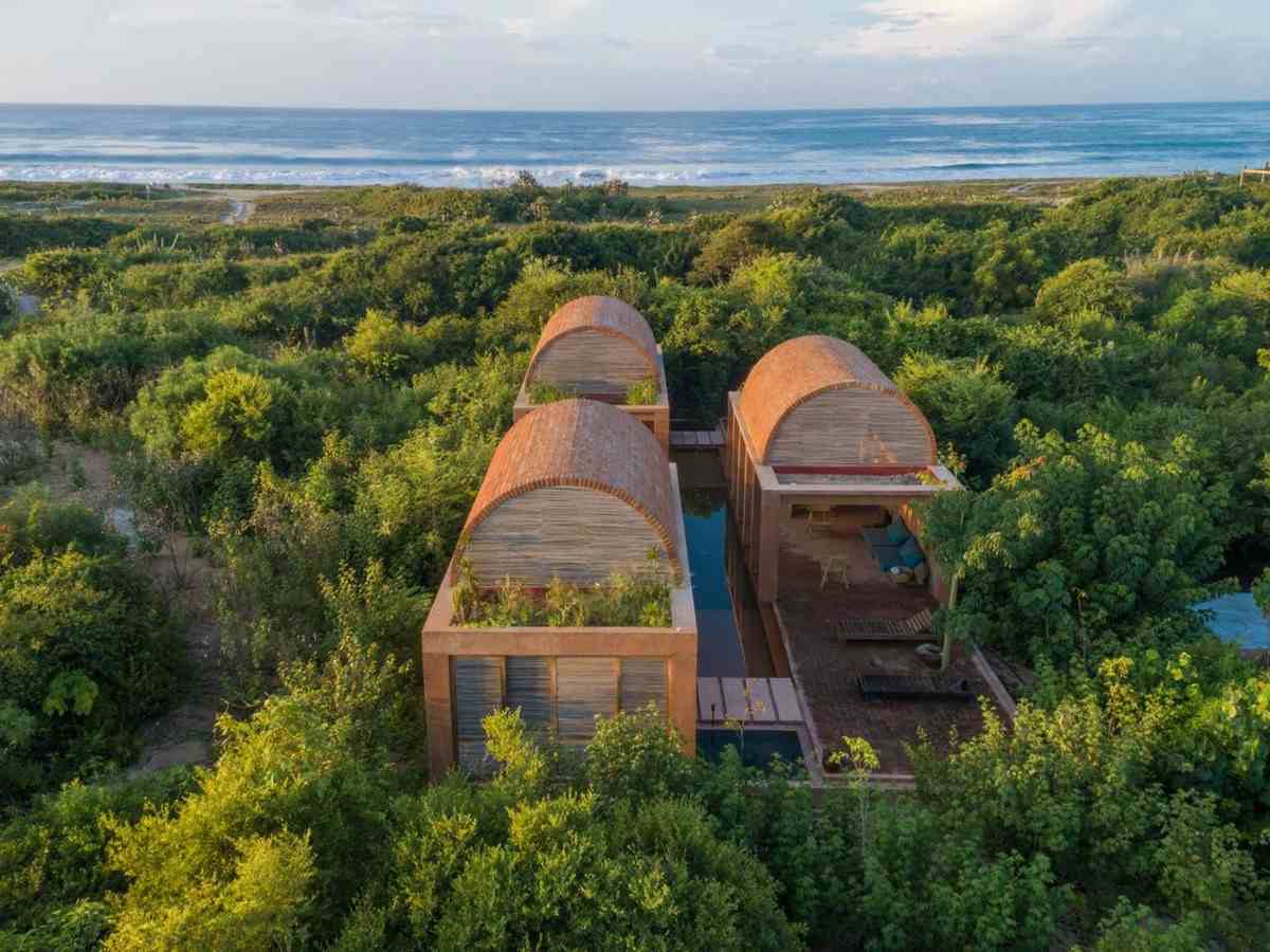 nádherná vila s klenutými tehlovými strechami a dlhým bazénom pri oceáne