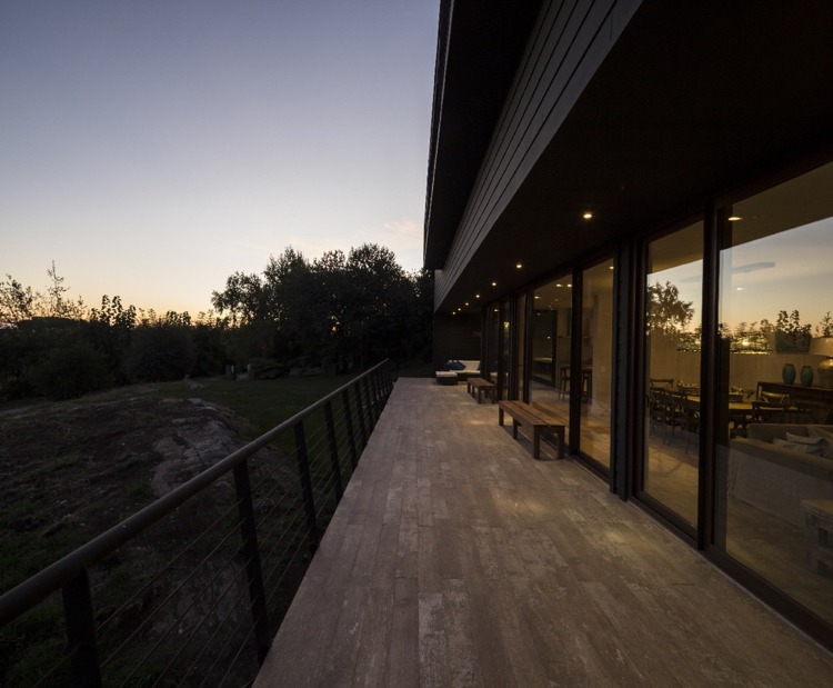 predĺžené terasy na každej strane domu moderný-fasádny-dizajn-čierny dom-terasa-podlhovasté-oceľové zábradlie