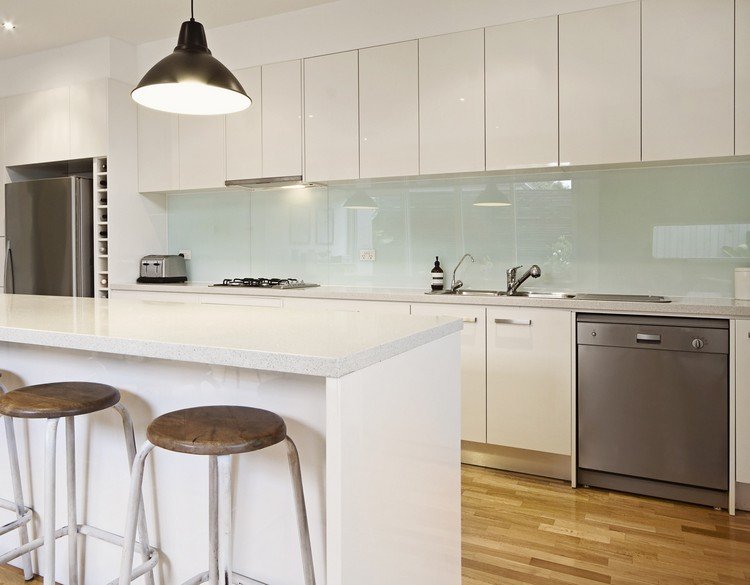 sklo-kuchyňa-ochrana pred striekajúcou vodou-pastelovo-zelená-biela-bezúchytkové-čela-laminátová podlaha