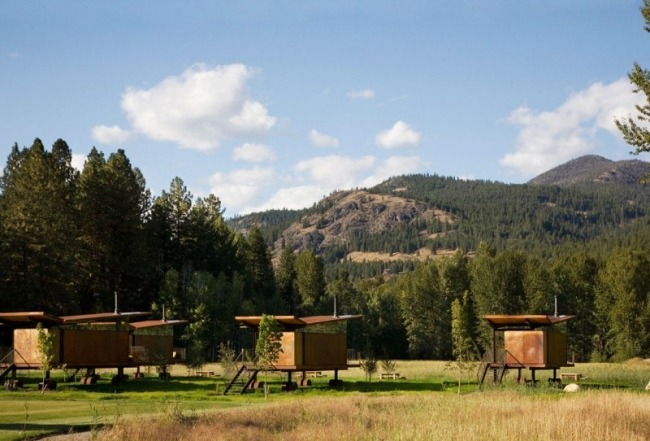 Moderné bungalovy s drevenými kolesami a oceľovým plášťom destinácie do hôr