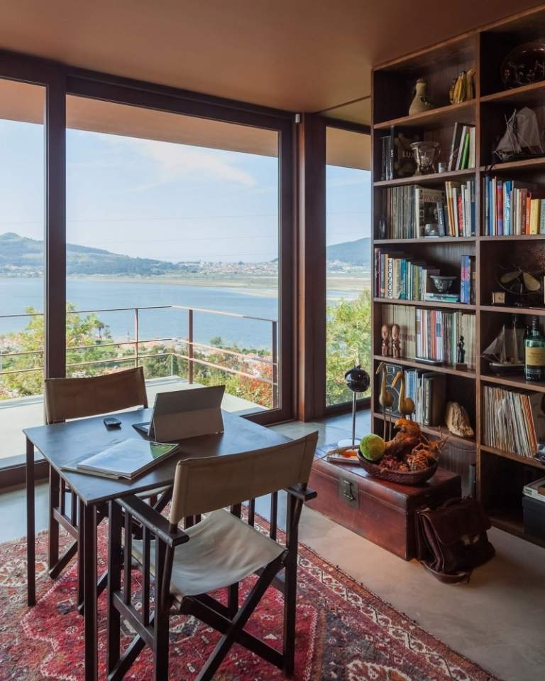 Dizajn miestnosti v hnedej farbe - nástenná polica - knihy - koberec kilim - drevo - tmavá - skladacie stoličky