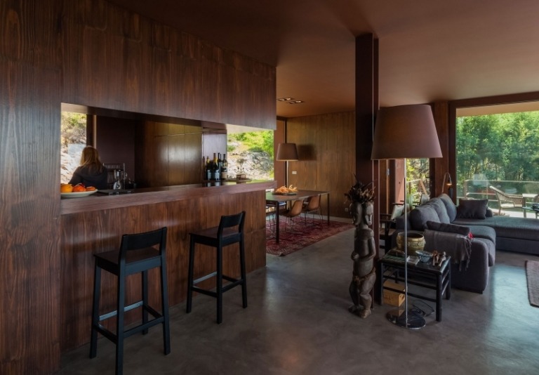 Interiérový dizajn v hnedej farbe-kuchynská linka-taburetka-rohová sedačka-stojanová lampa-afrika-socha-betónová podlaha