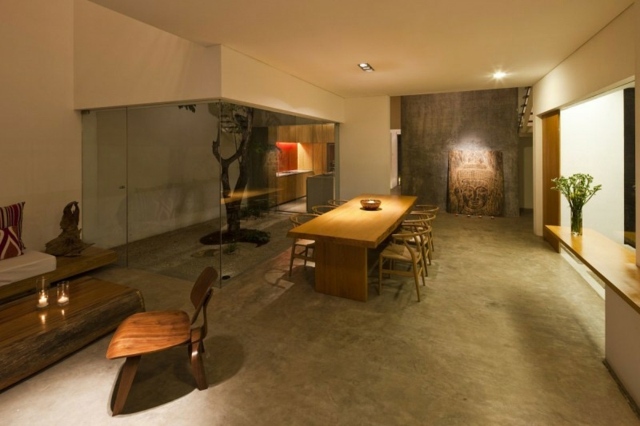 Obývacia časť betónová podlaha sklenená stena drevený stôl