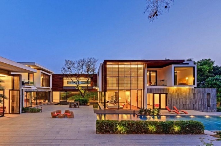 Moderný dizajn terasy s doskami z prírodného kameňa a vhodným osvetlením vo večerných hodinách moderný-terasový dizajn-osvetlenie bazéna-ležadlá-skupina na sedenie