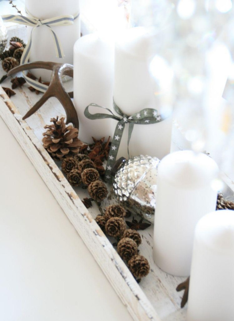 biele sviečky na tanieri ozdobené malými šiškami vianočné dekorácie-moderné-urob si sám-sviečky-šišky-parohy-kreatívne