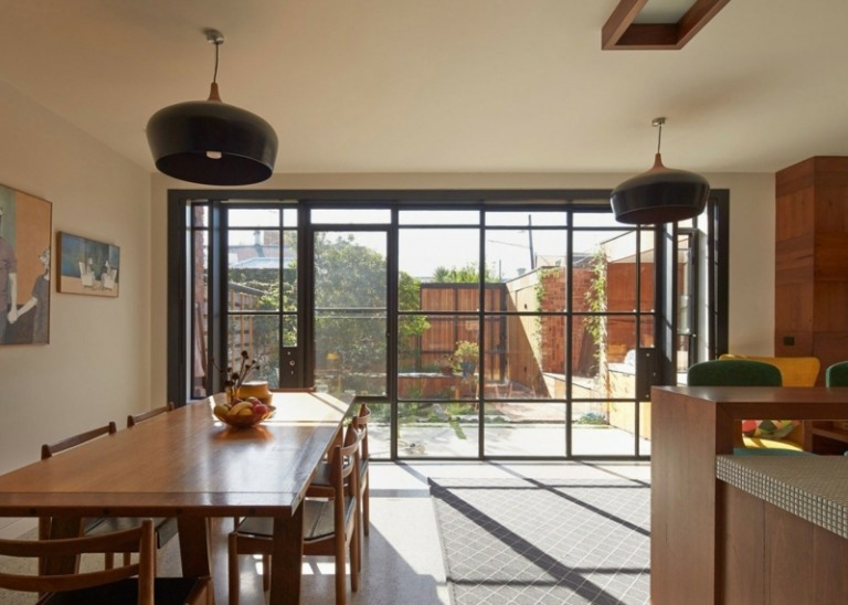 moderné točité schodisko vyrobené z dreveného okna predný čierny okenný rám jedálenský stôl