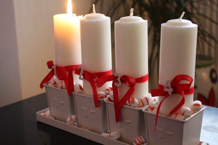 biele stĺpové sviečky v bielych kovových nádobách a červených stužkách Moderný adventný veniec -biely-stĺpový-sviečky-kovový-kontajnerový-cukrík-červená-stuha