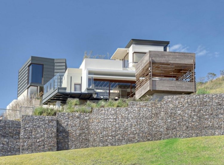 vysoká oporná stena z gabiónov a rôznych fasádnych obkladov dom vo svahu nesúci stenovo-gabionové-rôzno-fasádne obklady