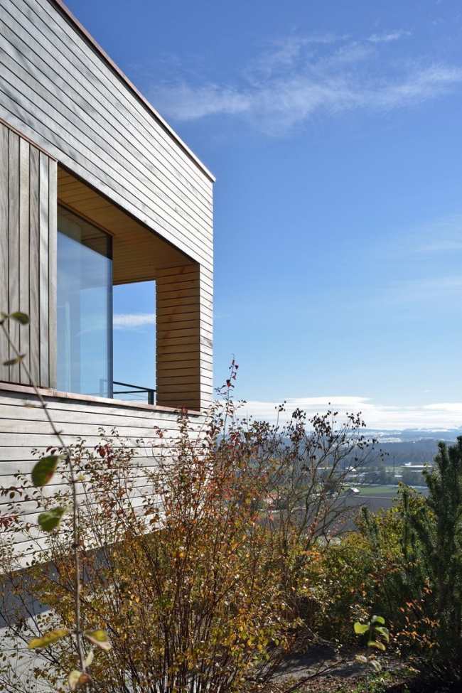 moderný dom na svahu so švajčiarskom s výhľadom na hory, drevená fasáda