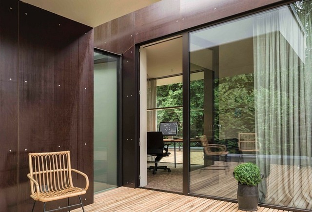 Ratanová stolička s otočnými dverami na verande s drevenou podlahou Štúdia obloženia verandy s drevenou podlahou a stenou