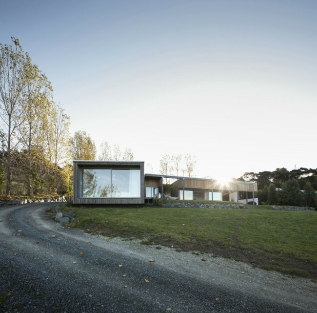 Sklenený fasádny prízemný dom s veľkými oknami Fasádny dom jednopodlažná budova veľké okná, okruhliaková cesta