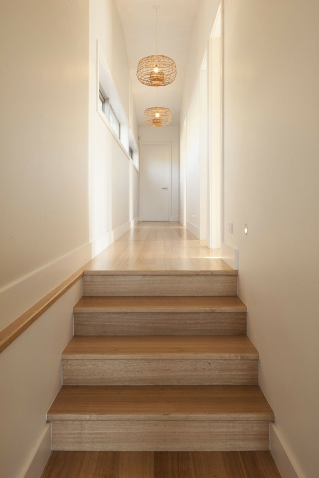 Moderné závesné drevené schodisko osvetľuje biele steny moderné závesné svetlá biele steny dizajn chodby