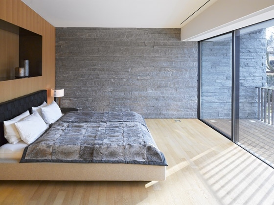 Spálňa z tehlovej steny s drevenou posteľou Spálňa z tehlovej steny s drevenou posteľou