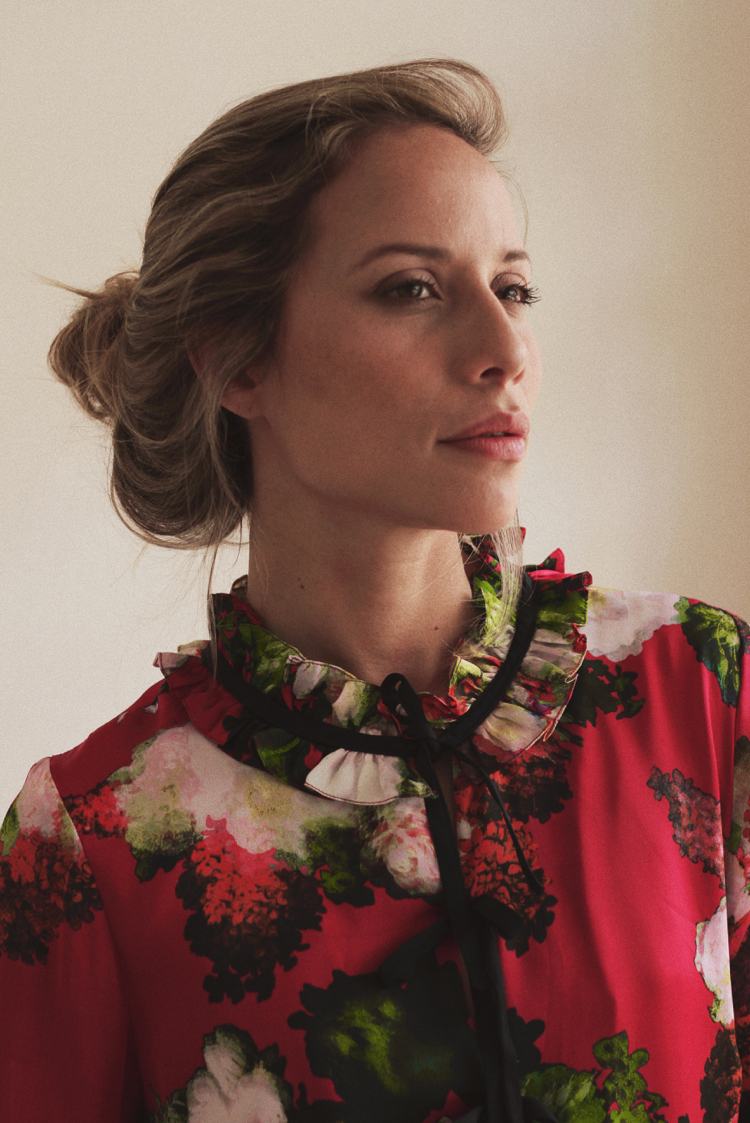 Cool blondína nosí červenú vzorovanú blúzku s akcentmi pistácie