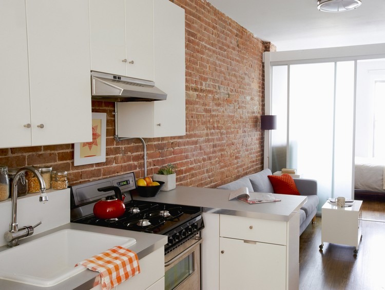 červená tehlová stena a biele skrine v jedálenskej kuchyni prírodný kameň-kuchyňa-červená-tehlová stena-obývačka-kuchyňa-biela-bariéra