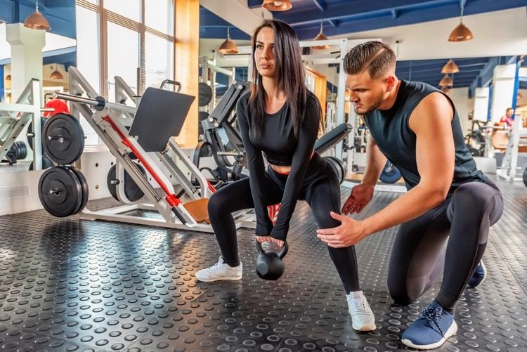 Squat so ženami cvičiacimi stehná Kettlebel