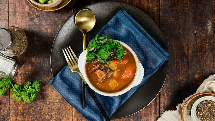 Oxtail polievku s petržlenovou vňaťou podávajte v malej miske s tanierikom a zodpovedajúcim príborom