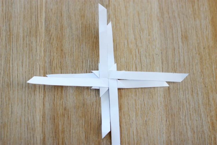 Pretiahnite všetky pásy a postupujte podľa obrázkových pokynov origami-vianocne-hviezdy-skladacie-navody-froebelstern-sklad-cez-biele pruhy-papierovy sklad