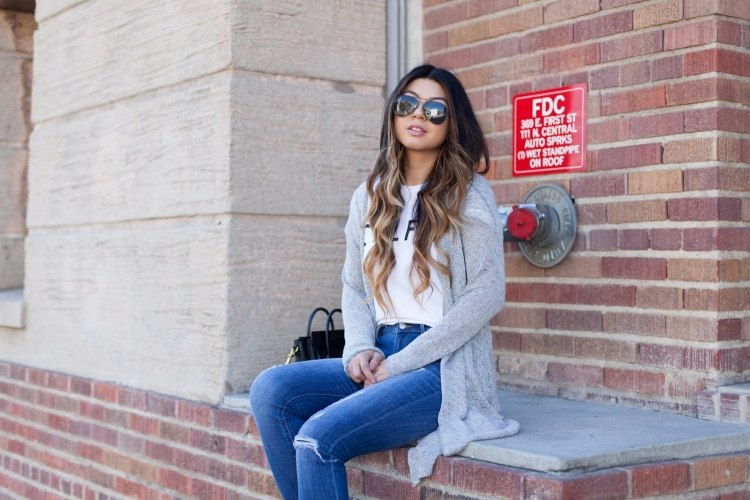 ležérny outfit so sivým svetrom, bielym tričkom a džínsami outfit-nápady-vesty-nadrozmerná-sivá-jemná-pletená-rifle-tehlové nástenné-slnečné okuliare