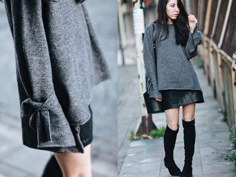 Nadrozmerný sveter v šedej farbe s krátkou koženou sukňou a nadkolienkami