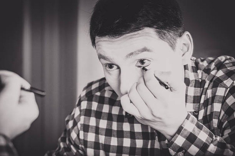 muž s károvanou košeľou pantomimicky líči s okuliarmi alebo bez nich