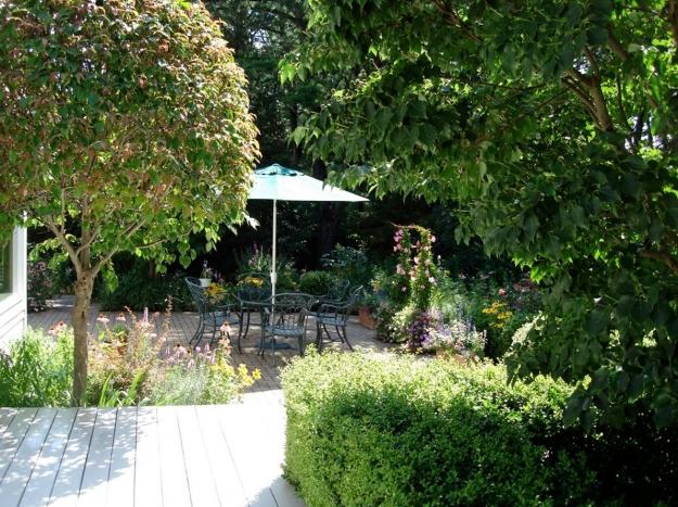 útulné posedenie v záhradných stoličkách jedálenský stôl slnečník so stojanom