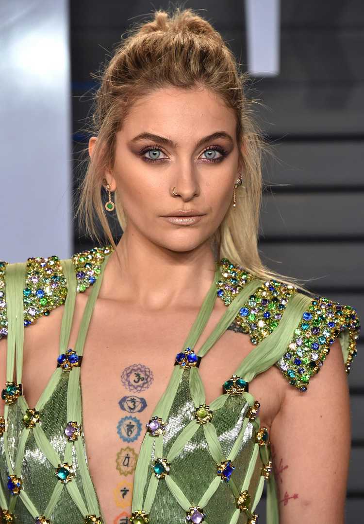 Paris Jackson so svetlými blond vlasmi na hrudi vytetovaných siedmimi čakrami