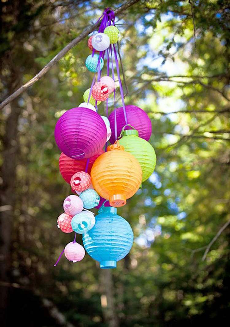 Farebná párty dekorácia vyrobená z lampiónov v rôznych veľkostiach letná párty party dekorácia papierové lampáše osvetlenie nápad farebné farby záhrada