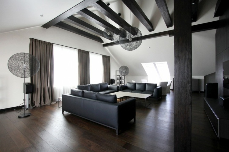 Penthouse má v obývacej izbe aj pekné strešné trámy monochromatický penthouse dizajnový gauč z čiernej koženej drevenej podlahy