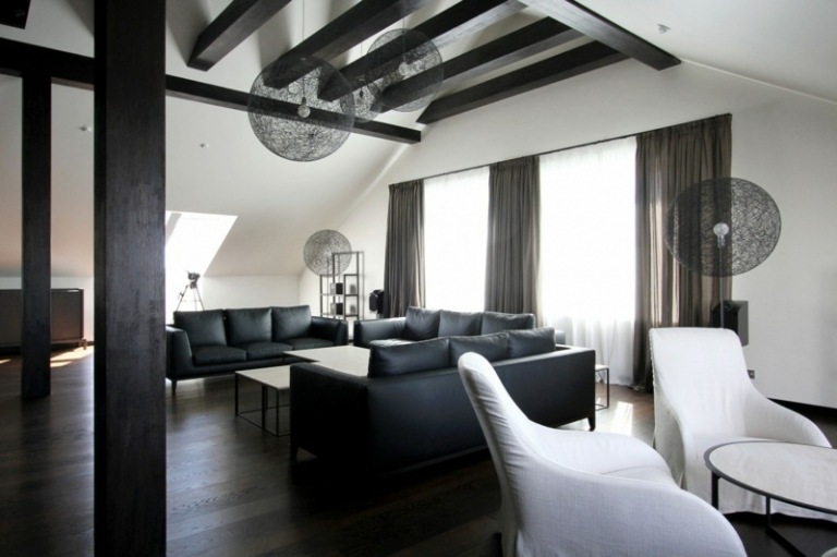 Penthouse dizajn v monochromatickom štýle od Ramuna Manikas penthouse dizajn obývacia izba kožená sedačka strešné nosníky parkety