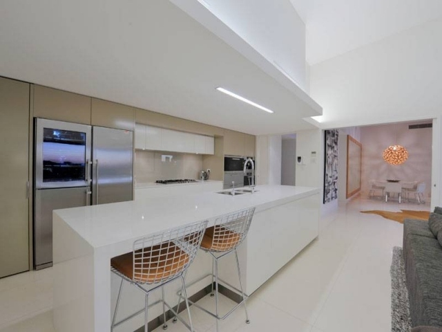 biela-vysoký lesk-kuchynský-ostrov-stoličky-vstavaná-chladnička-nerez