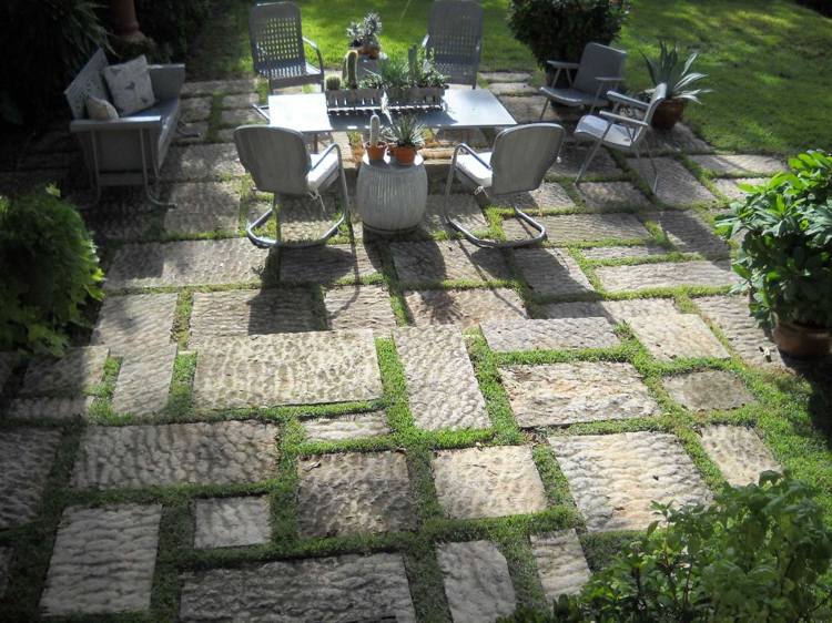 Zelené škáry medzi terasovými doskami Zelený spoj rastlín medzi kamennými doskami terasový efekt