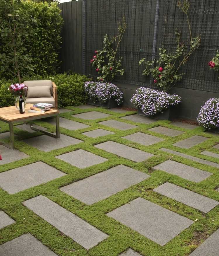 Obdĺžnikové betónové dosky položte naprieč a pozdĺžne zelené kĺby-rastliny medzi kamennými doskami-terasa-asymetrický-moderný dizajn