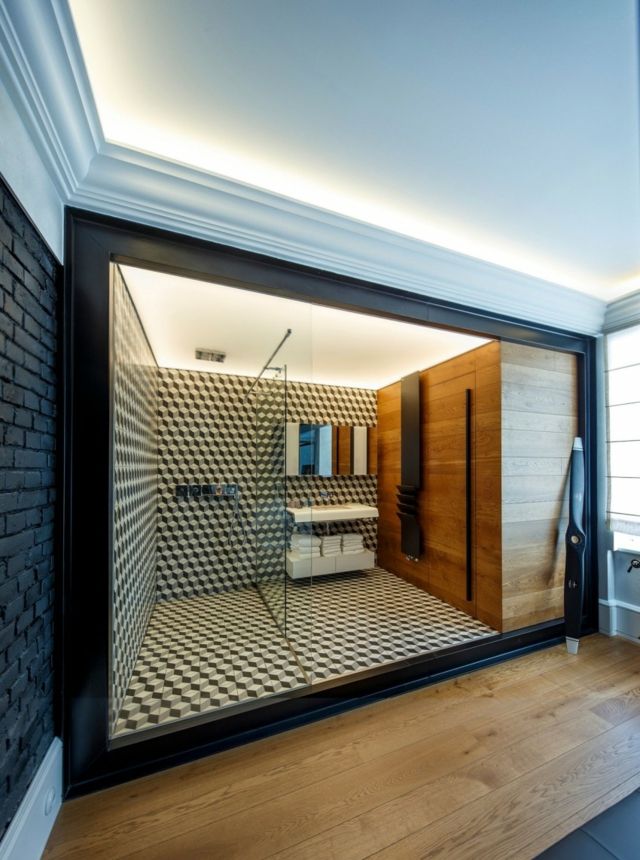 Súkromná domáca kúpeľňa so sprchovacím kútom a umývadlom Sprchovaci-a-drezovy-priestor-s-priečkou-zo-skla-obkladu-steny-z-dreva