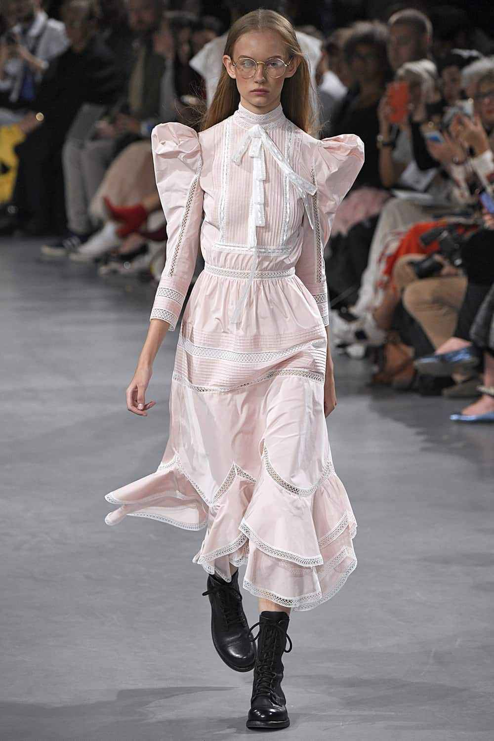 Prairie šaty kombinujú módny trend s nafúknutými rukávmi, retro šaty, čierne motorkárske členkové čižmy, okrúhle slnečné okuliare