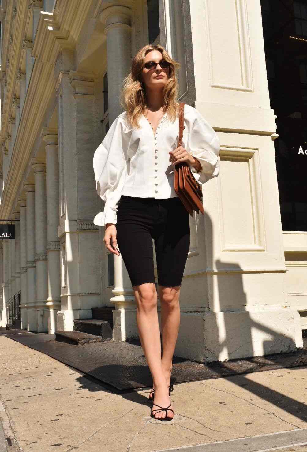 Cyklistické šortky kombinujú košeľovú blúzku s nafúknutými rukávmi módne trendy letná medová blond farba vlasov