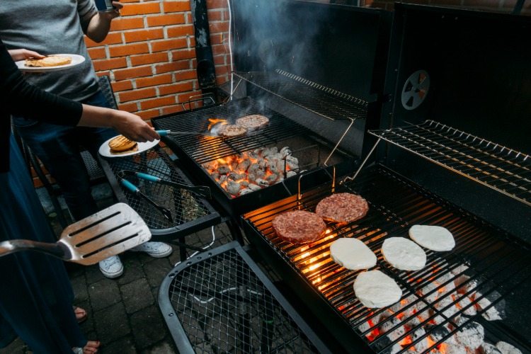 preklápanie hamburgerov na vonkajšom grile