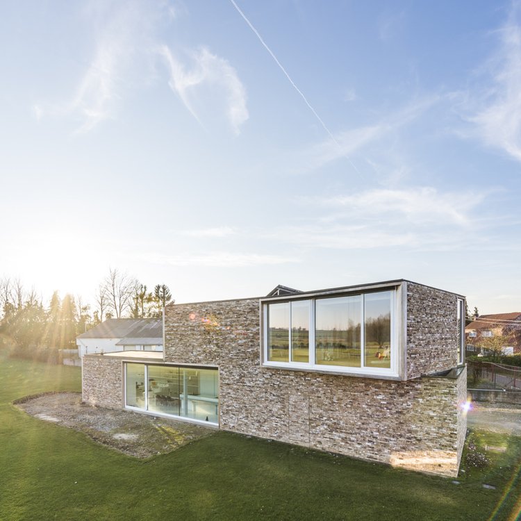 Fasádny dom z prírodného kameňa s modernou plochou strechou