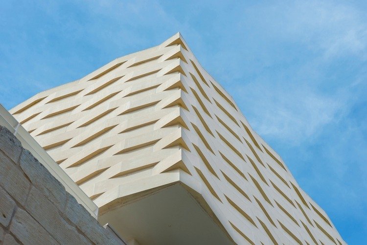 budova s ​​fasádnym obkladom z popruhov v žltej farbe