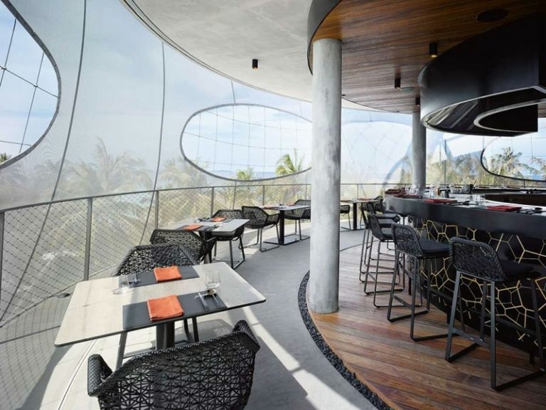 reštaurácia s dreveným stojanom na víno, barové stoly, kruhový tvar