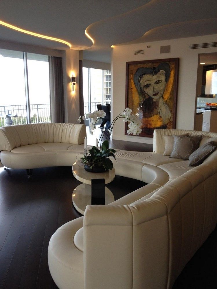 okrúhle pohovky-moderná-koža-ecru-tmavá-drevená-podlaha-okrúhla-konferenčný stolík-biela-orchidea