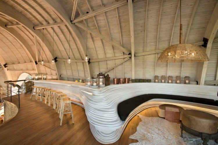 bar z naplaveného dreva organická lampa, parketová kožušinová barová stolička