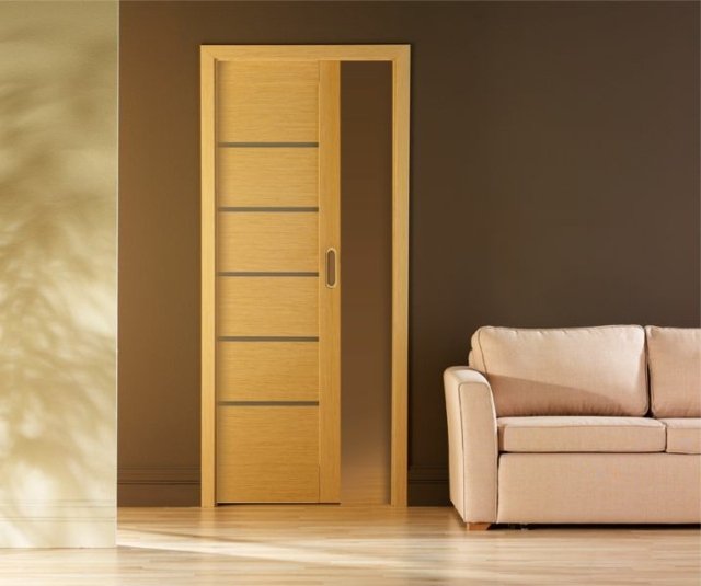 hnedá stena čalúnená sedacia súprava posuvné drevené dvere čalúnená pohovka v minimalistickom dizajne